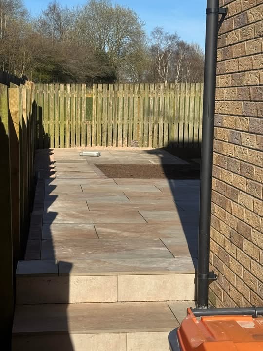 Sawn buff sandstone side path running between the house and fence line
