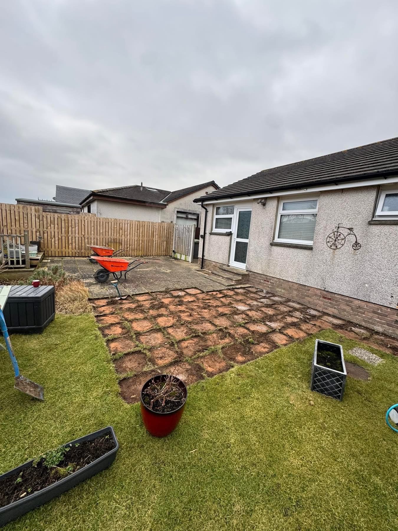 Before — broken brick and tired concrete patio at the rear of the bungalow