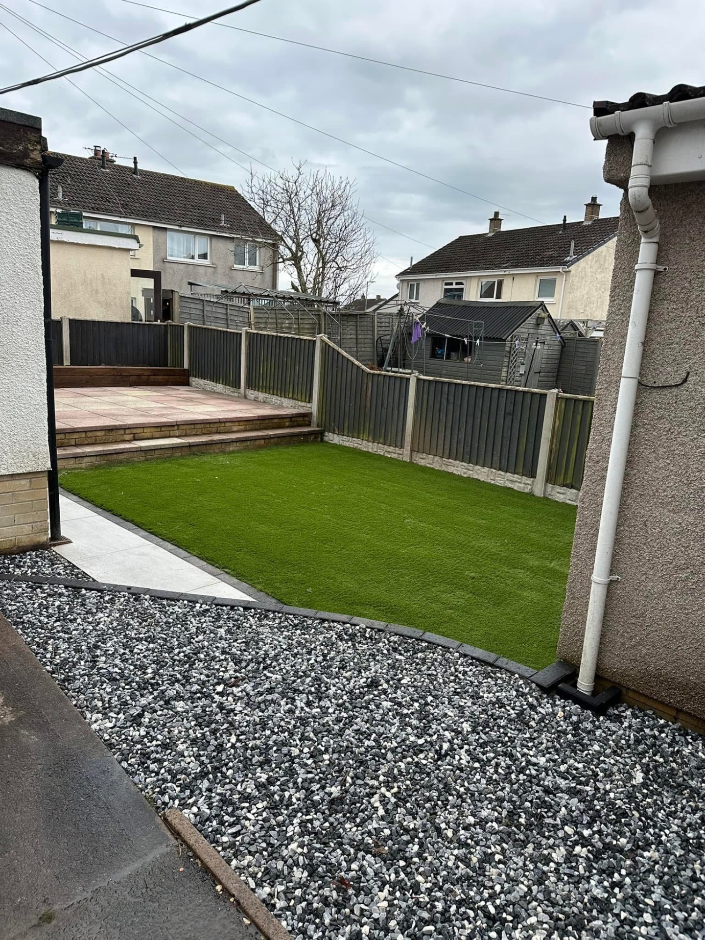 Compact artificial lawn with stepped patio above — Annan