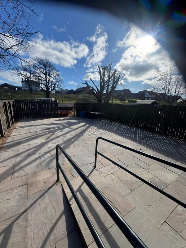 Close view of the accessible step and twin powder-coated handrails on the sandstone patio